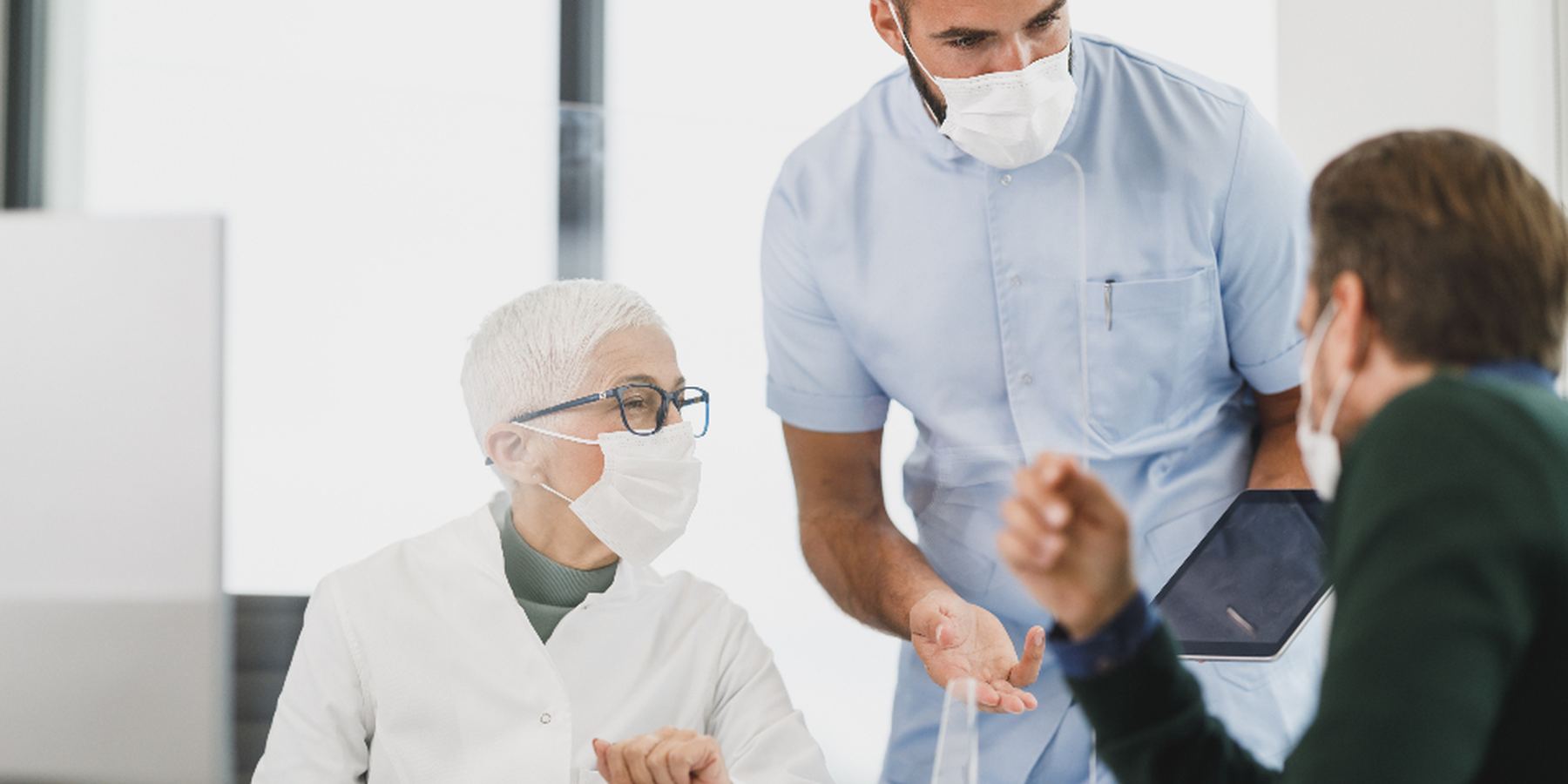 A healthcare team in discussion at a nurses station