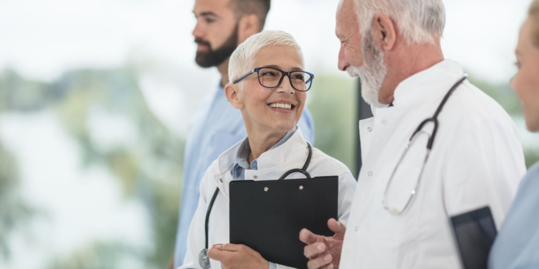 Clinicians conferring over a chart on a hospital ward